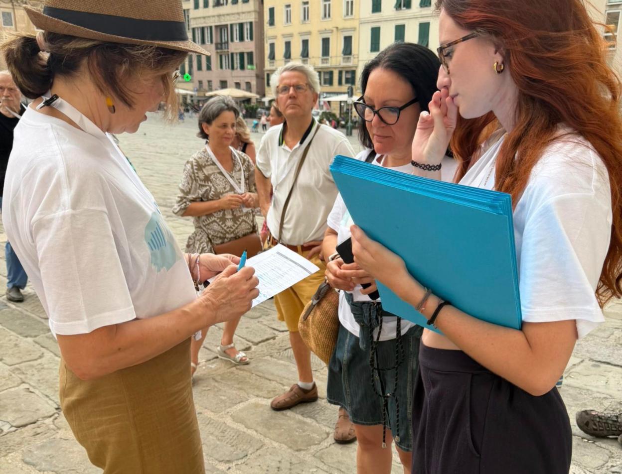 Partecipanti alla caccia al tesoro Face to Fake in Piazza Matteotti a Genova, con le cartelline del gioco